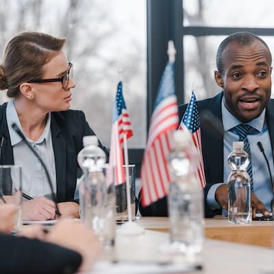 selective focus of attractive businesswoman looking at african american diplomat